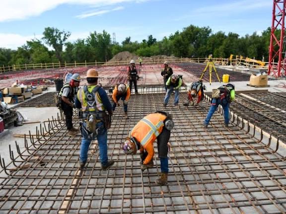 A crew tying rebar across a wide foundation deck