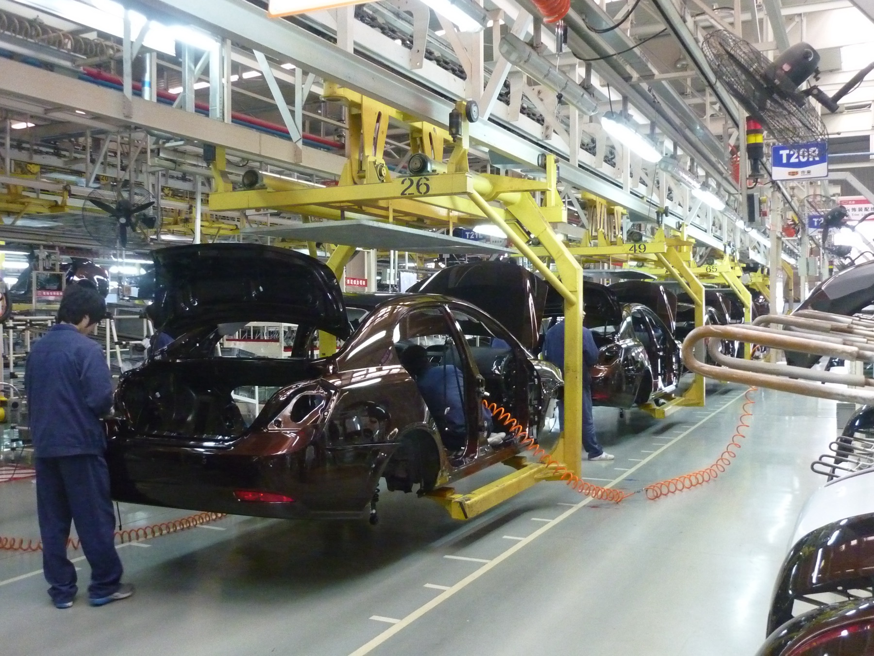 Workers on an automotive assembly line inside a factory